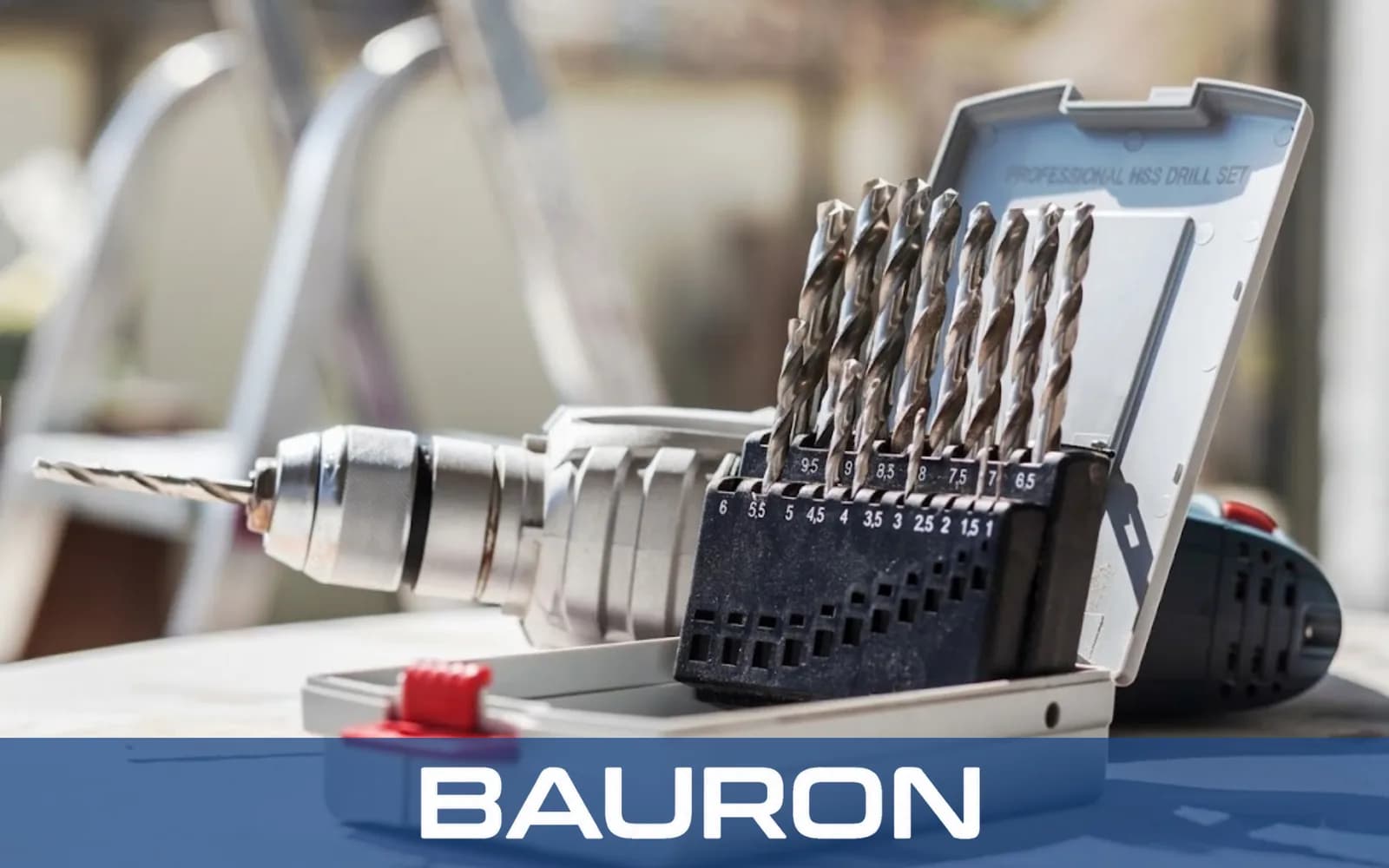 HSS-Spiralbohrersatz in einer Kassette neben dem Bohrfutter einer Bohrmaschine